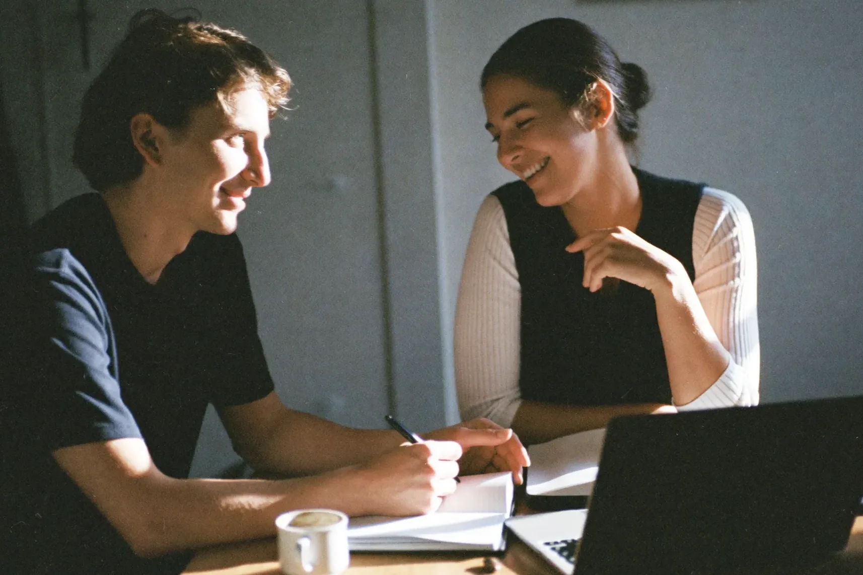A couple planning together over coffee and a notebook at their kitchen table